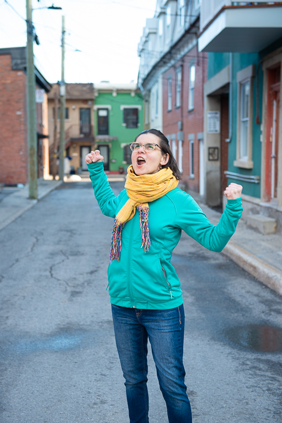 Femme avec les bras élevés dans une ruelle montréalaise.